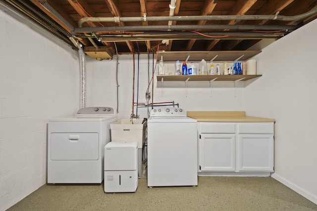 laundry room featuring cabinets, washer and clothes dryer, and sink