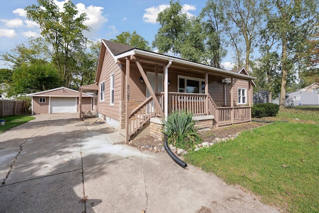 view of front of home featuring covered porch, a garage, an outdoor structure, and a front yard