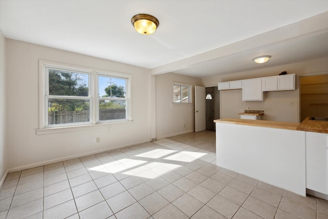 interior space featuring light tile patterned floors and white cabinetry