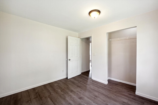 unfurnished bedroom featuring a closet and dark wood-type flooring