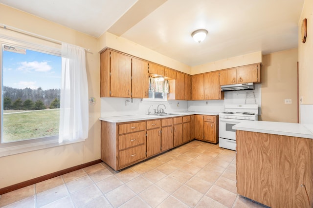 kitchen featuring sink, light tile patterned flooring, and white stove