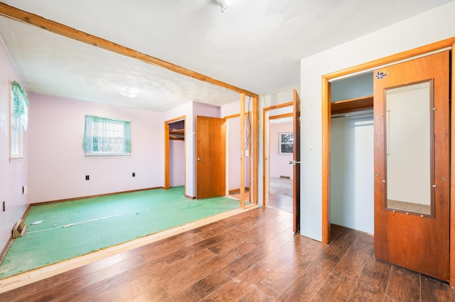 unfurnished bedroom with dark wood-type flooring