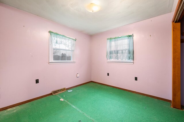 unfurnished room with carpet floors and plenty of natural light