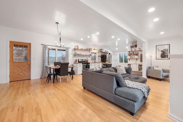 living room with light wood-type flooring and a chandelier