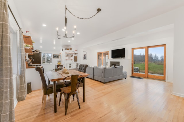 dining room featuring a chandelier, a wealth of natural light, and light hardwood / wood-style floors