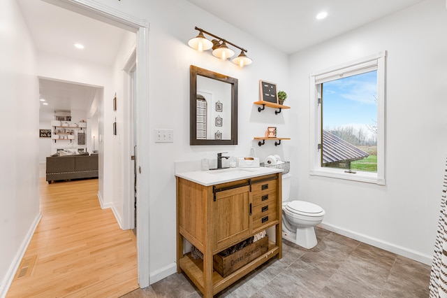 bathroom with vanity, wood-type flooring, and toilet