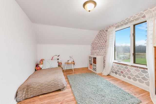 bedroom featuring hardwood / wood-style flooring and lofted ceiling