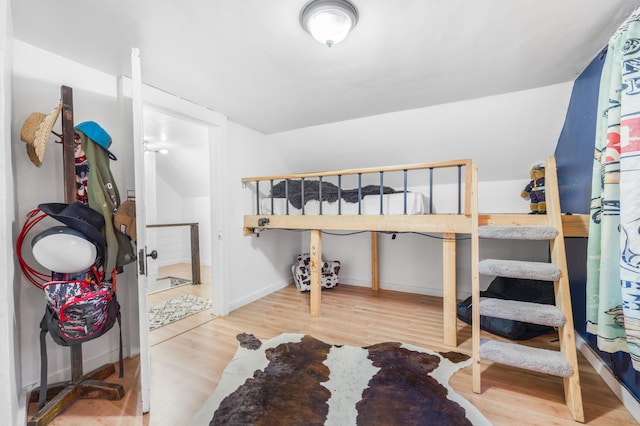 bedroom with hardwood / wood-style flooring and lofted ceiling