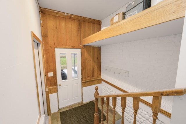 interior space featuring wooden walls and brick wall