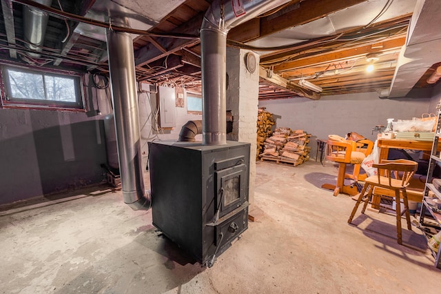 basement with a wood stove and electric panel