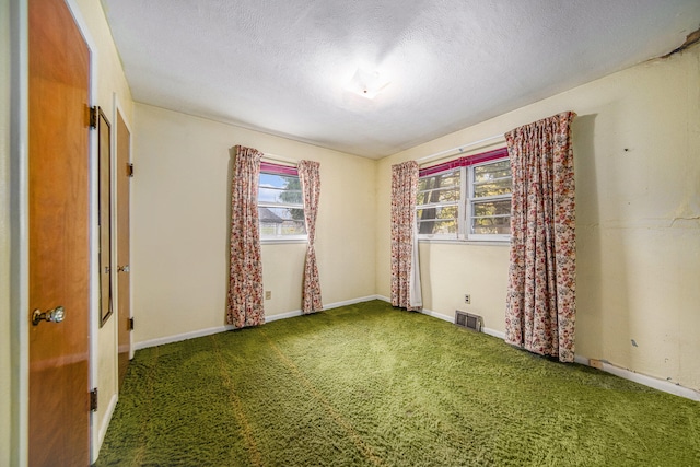 spare room featuring carpet floors, a textured ceiling, and golf simulator