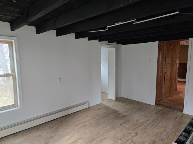 spare room featuring hardwood / wood-style floors, baseboard heating, and beamed ceiling