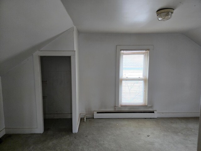 additional living space featuring carpet, a baseboard heating unit, and lofted ceiling