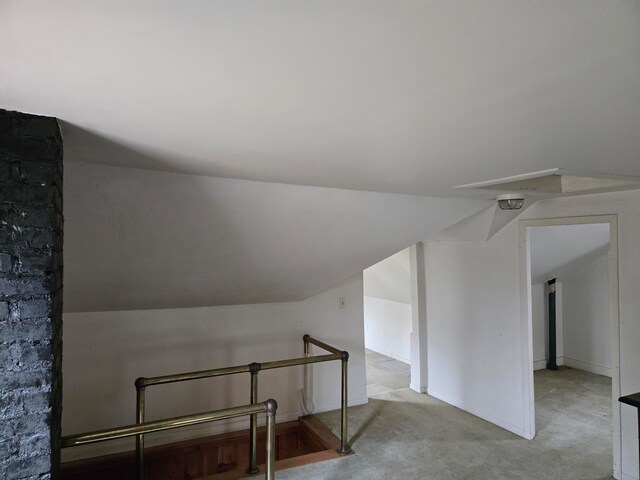 bonus room featuring light carpet and vaulted ceiling