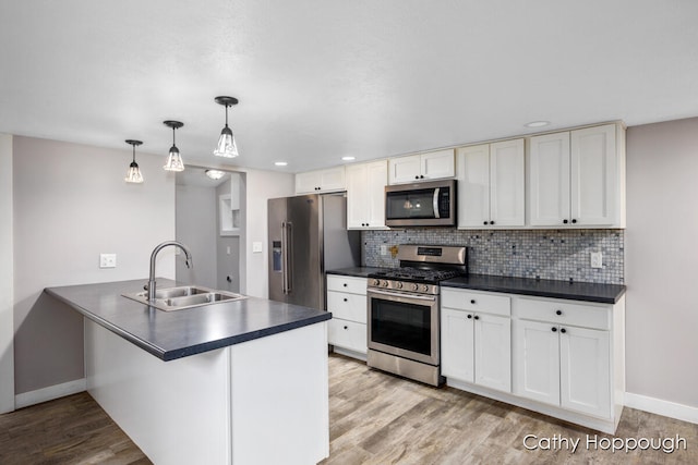 kitchen with white cabinets, decorative light fixtures, stainless steel appliances, and sink