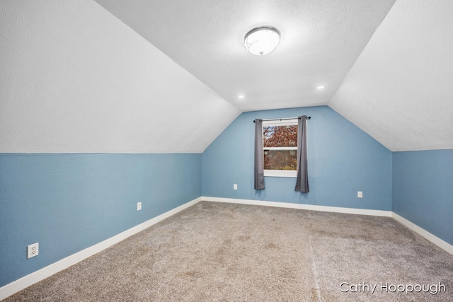 bonus room featuring carpet, a textured ceiling, and vaulted ceiling