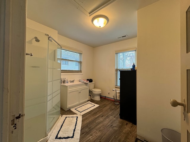 bathroom with toilet, vanity, an enclosed shower, and hardwood / wood-style flooring