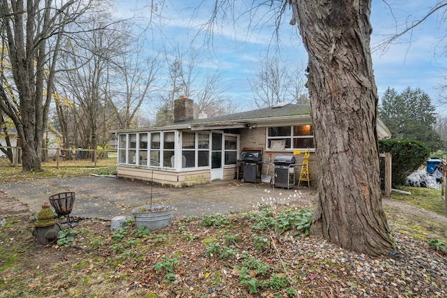 back of property with a patio area and a sunroom