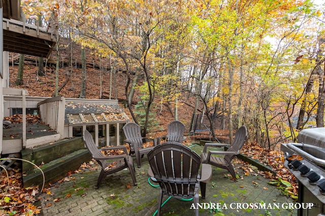 view of patio featuring a grill, a sunroom, a wooden deck, and a trampoline