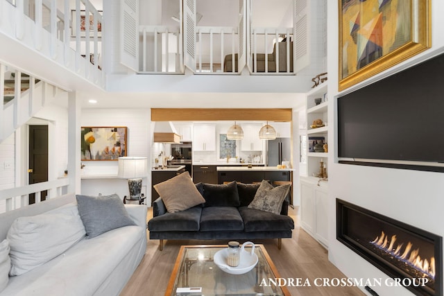 living room with a towering ceiling and hardwood / wood-style flooring