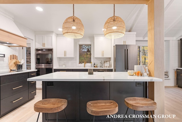 kitchen featuring a breakfast bar area, white cabinetry, and black appliances