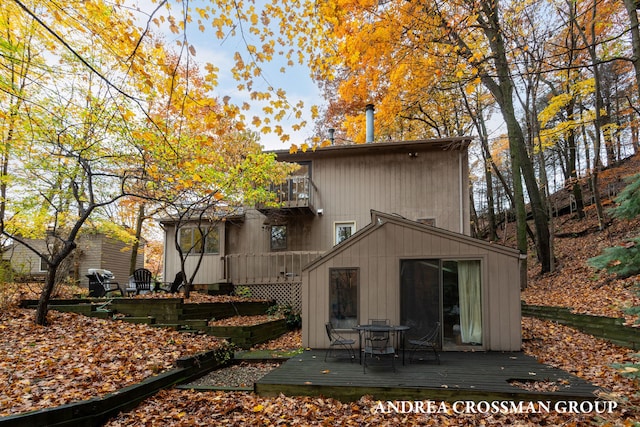 rear view of house featuring a balcony and a deck