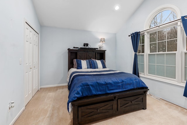 carpeted bedroom with a closet and lofted ceiling