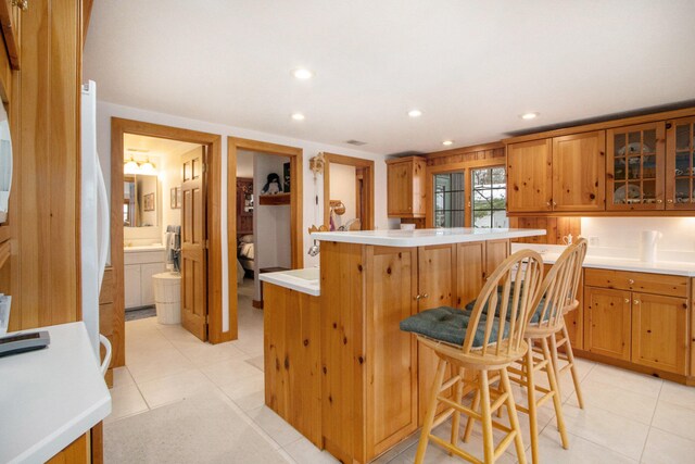 kitchen featuring a breakfast bar area, a center island, and light tile patterned floors