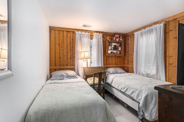 bedroom featuring wooden walls