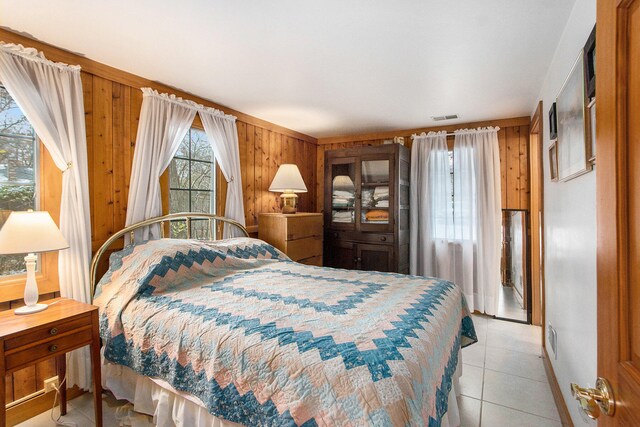 tiled bedroom featuring wooden walls