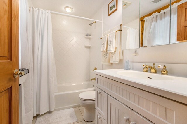 full bathroom featuring tile patterned floors, shower / bath combo with shower curtain, vanity, and toilet