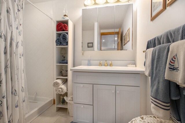 bathroom featuring tile patterned flooring, a shower with curtain, and vanity