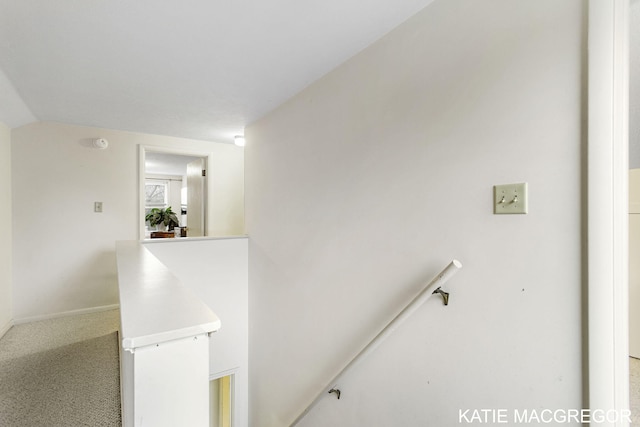 hallway featuring carpet floors and vaulted ceiling