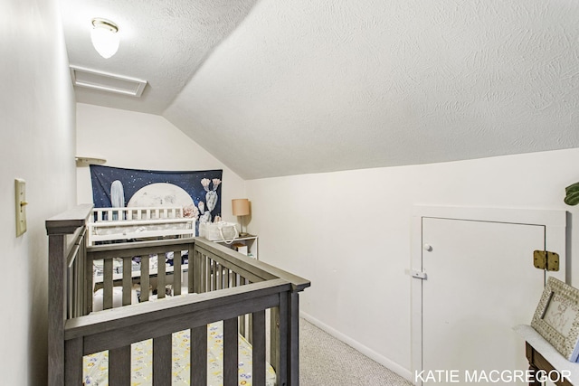 bedroom with a crib, carpet floors, a textured ceiling, and vaulted ceiling