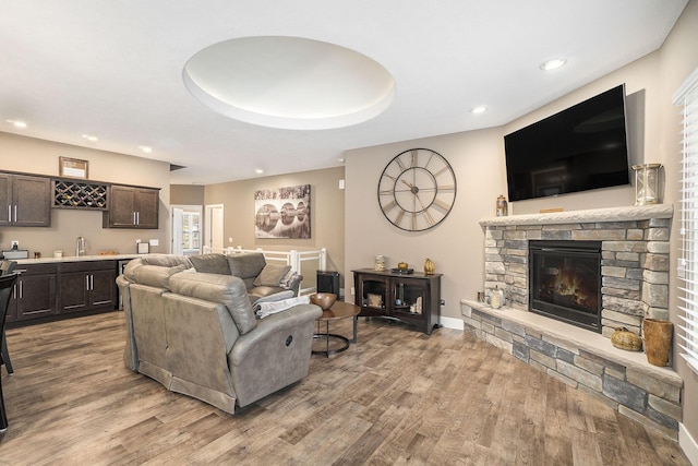 18481 N Fruitport Rd, Spring Lake, MI 49456 - living area with bar with sink, a fireplace, wood finished floors, recessed lighting, and baseboards