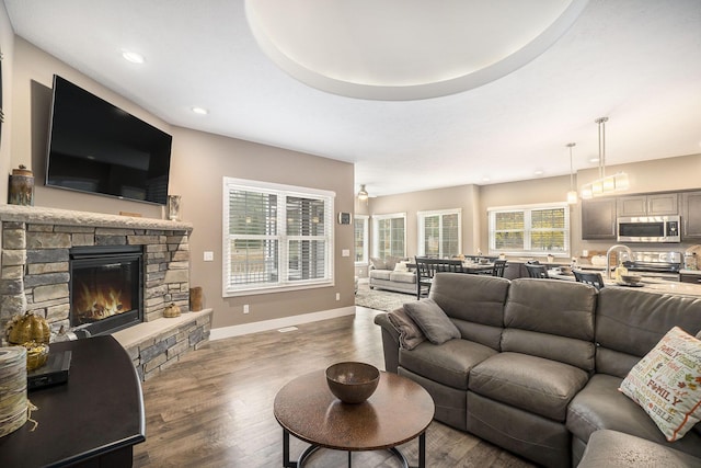 18481 N Fruitport Rd, Spring Lake, MI 49456 - living area with a stone fireplace, wood finished floors, recessed lighting, and baseboards