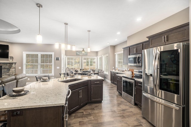 18481 N Fruitport Rd, Spring Lake, MI 49456 - kitchen with appliances with stainless steel finishes, open floor plan, a sink, dark brown cabinets, and recessed lighting