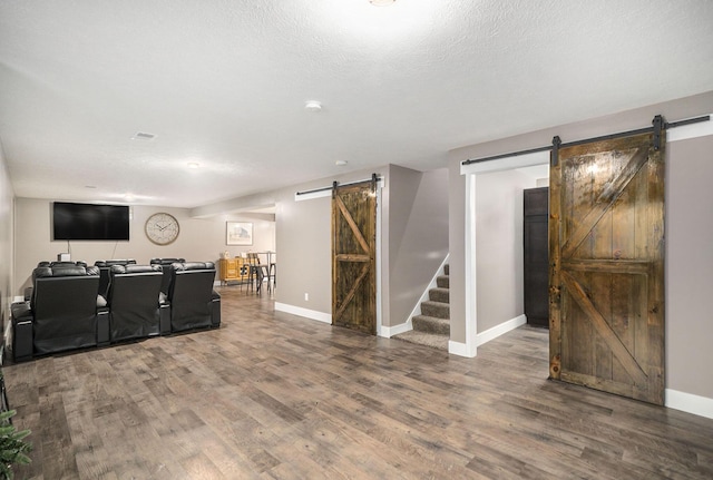 18481 N Fruitport Rd, Spring Lake, MI 49456 - living area featuring a barn door, wood finished floors, baseboards, stairs, and a textured ceiling