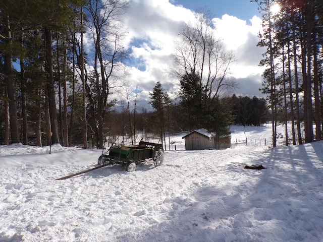 snowy yard featuring a storage shed