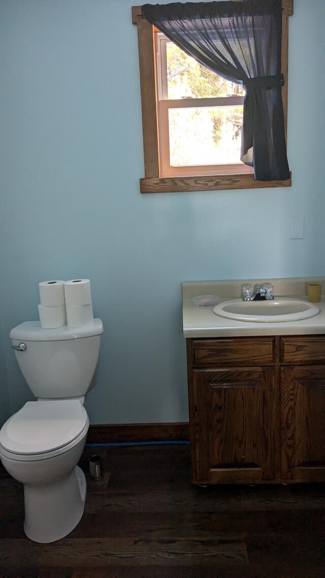 bathroom featuring toilet, vanity, and hardwood / wood-style flooring