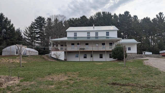 7909 11 Mile Rd, Bear Lake, MI 49614 - rear view of property with a lawn, a greenhouse, an outbuilding, and metal roof