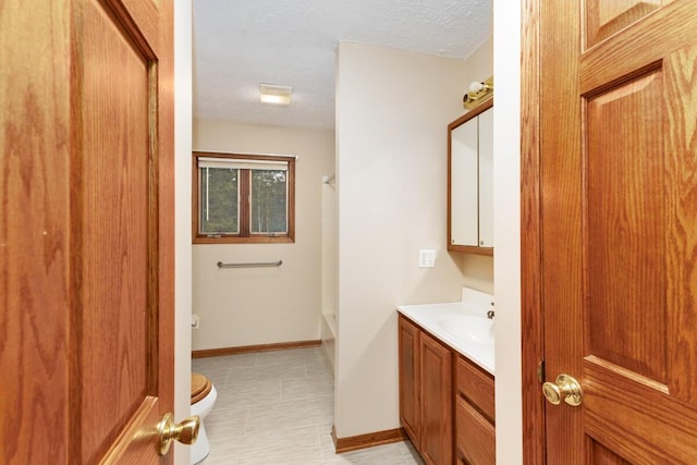 bathroom featuring vanity, toilet, and a textured ceiling