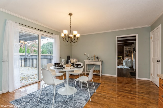 dining space featuring dark hardwood / wood-style flooring, an inviting chandelier, and ornamental molding