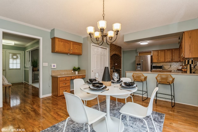 dining area featuring hardwood / wood-style floors, a textured ceiling, crown molding, and a chandelier