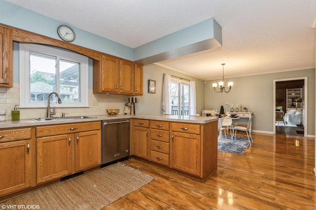 kitchen with kitchen peninsula, sink, hardwood / wood-style flooring, dishwasher, and plenty of natural light