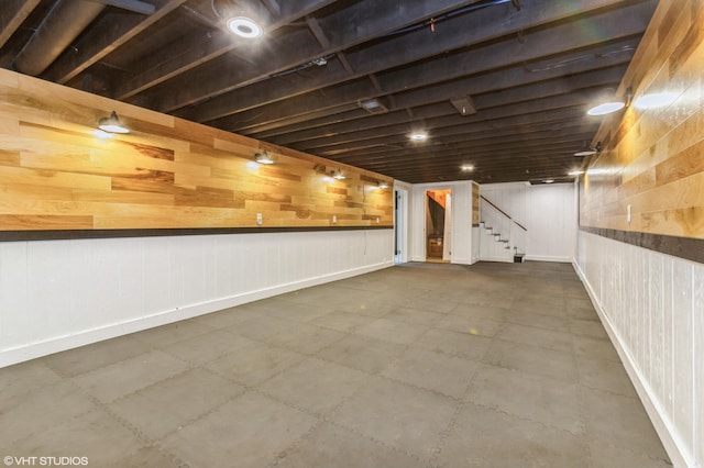 basement featuring wooden walls