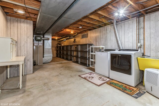 basement featuring separate washer and dryer and wood walls