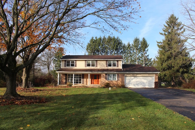 9370 Moon Rd, Saline, MI 48176 - traditional home with asphalt driveway, a garage, a front yard, and brick siding
