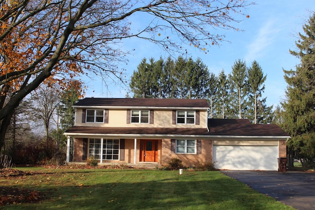 9370 Moon Rd, Saline, MI 48176 - traditional home featuring a garage, driveway, brick siding, and a front lawn