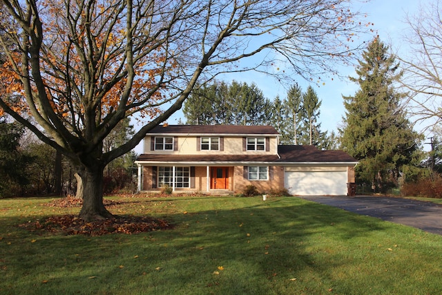 colonial house with a front yard and a garage